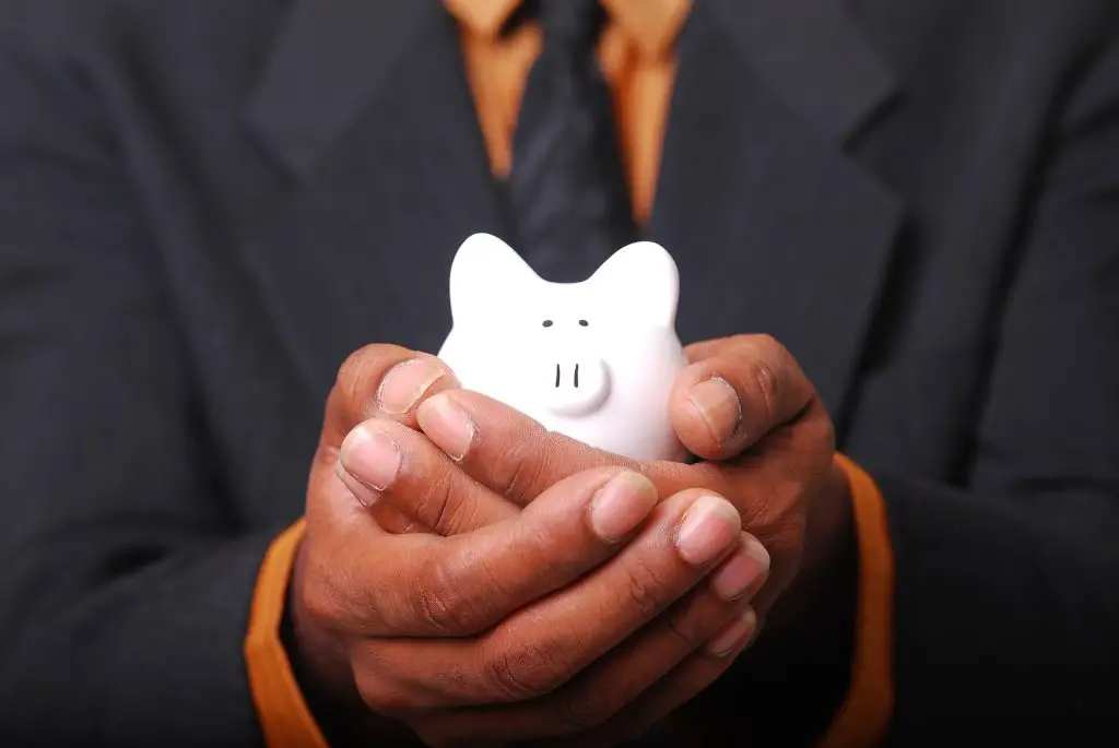 a man holding a small piggy bank