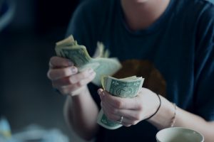 how to shop for a washer and dryer? Have a budget. a picture of a woman counting dollar bills